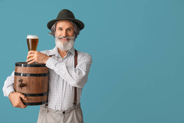 Hombre mayor guapo en ropa tradicional alemana y con cerveza sobre fondo de color - Foto, Imagen