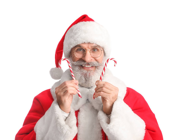 Santa Claus with sweet candy canes on white background - Foto, Imagen