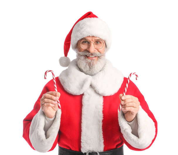Santa Claus with sweet candy canes on white background - Fotó, kép