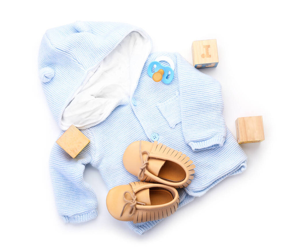 Roupas de bebê, sapatos, brinquedos e chupeta no fundo branco - Foto, Imagem