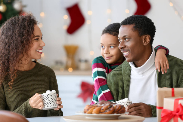 Feliz familia afroamericana bebiendo sabroso chocolate caliente en casa en la víspera de Navidad - Foto, Imagen