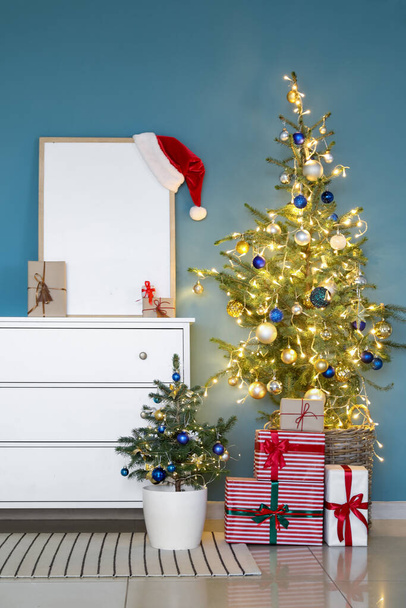 Laatikot tyhjällä kehyksellä, lahjat ja joulukuuset lähellä sinistä seinää - Valokuva, kuva