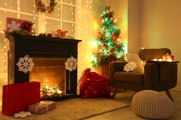 Interior de la sala de estar con chimenea, árbol de Navidad y luces brillantes - Foto, imagen