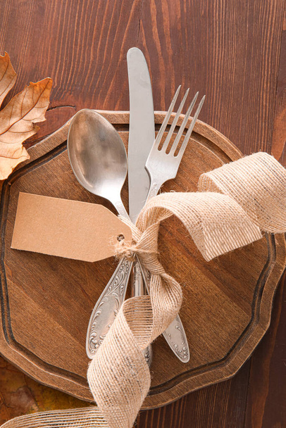 Composition with table setting and blank tag on wooden background - Foto, Imagem