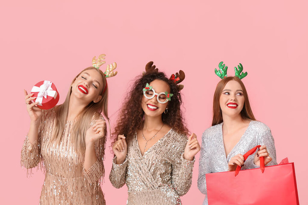 Piękne młode kobiety z wystrojem świątecznym i prezenty na tle koloru - Zdjęcie, obraz