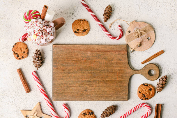 Bardaklı kompozisyon lezzetli kakao, baston şekerler, tahta tahta tahta ve açık arkaplanda kurabiyeler - Fotoğraf, Görsel