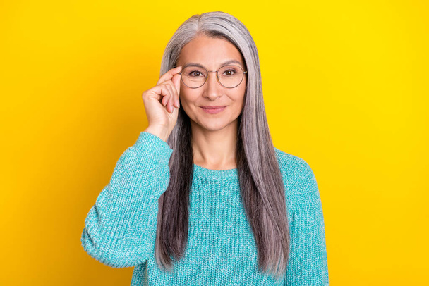 Photo of pretty senior lady hand touch eyeglasses smart leader agent isolated over yellow color background - 写真・画像