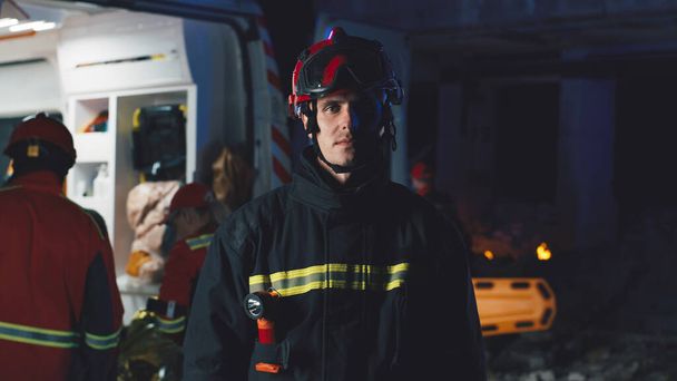 夜に救急車の近くに立つ男性救助者 - 写真・画像