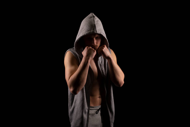 Sportmann Kämpfer stehend Hände hoch in dunklem Raum isoliert. UFC, Box, MMA Concept. Sportler kampfbereit - Foto, Bild