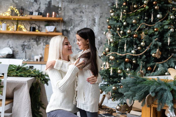 Friendship and love of mom and daughter. Family values. Preparing to celebrate Christmas. Christmas tree decoration. Building a good relationship between mother and daughter. - Foto, Imagen