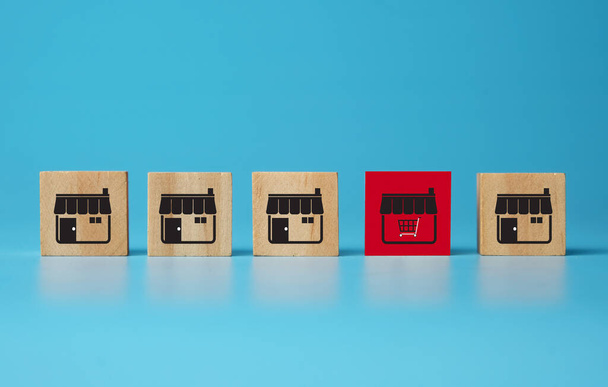 Une image de blocs de jouets en bois cube avec l'icône du magasin d'affaires de franchise dans le panier. Concepts de marché électronique en ligne ou de franchisage du commerce électronique à la croissance. - Photo, image