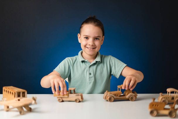 Lindo niño caucásico jugando juguete de madera en la mesa - Foto, Imagen