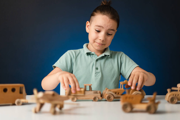 Bonito criança caucasiana jogando brinquedo de madeira na mesa - Foto, Imagem