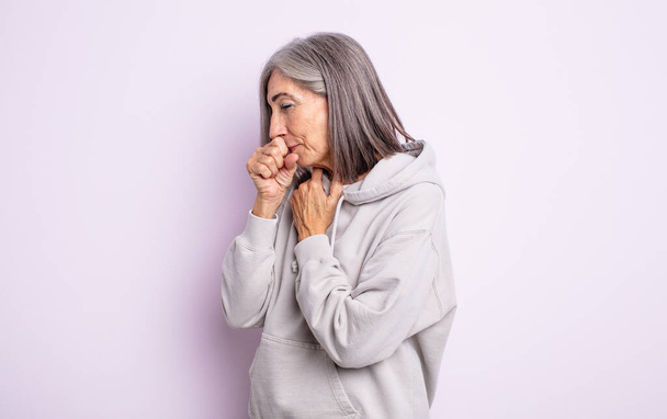 idős csinos nő rosszul érzi magát a torokfájás és influenza tünetei, köhögés szájjal fedett - Fotó, kép