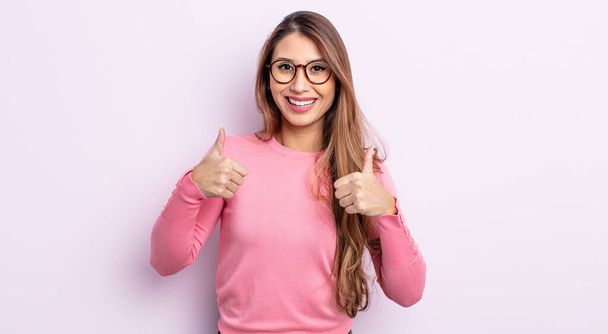asian pretty woman smiling broadly looking happy, positive, confident and successful, with both thumbs up - Фото, изображение