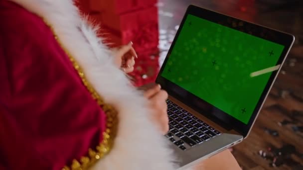 clouse-up, mujer feliz Sra. Santa se comunica en el ordenador portátil en su oficina de Navidad. vacaciones en cuarentena. comunicación remota, regalos de vacaciones y descuentos. - Metraje, vídeo
