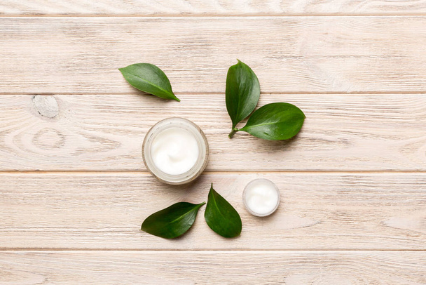 Organic cosmetic products with green leaves on wooden background. Flat lay. - Photo, Image