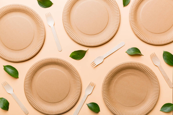 set of empty reusable disposable eco-friendly plates, cups, utensils on light white colored table background. top view. Biodegradable craft dishes. Recycling concept. Close-up. - Photo, Image