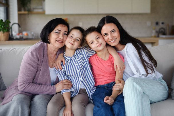 Happy small girls with mother and grandmother indoors at home, looking at camera. - Fotografie, Obrázek