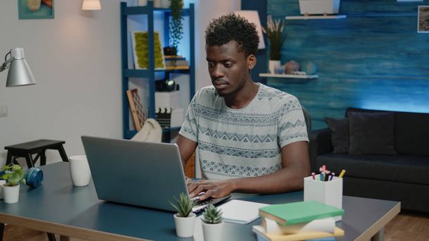 Homem de negócios de etnia africana usando laptop para trabalho remoto online - Foto, Imagem