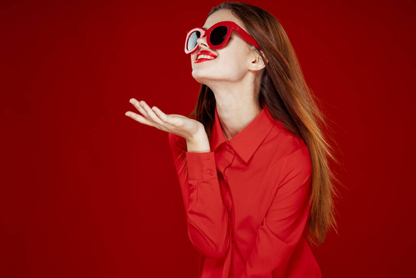 beautiful woman wearing sunglasses red shirt makeup isolated background - Foto, immagini