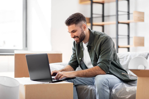 homem com computador portátil e se movendo para uma nova casa - Foto, Imagem