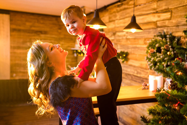 Portrait of happy mother and adorable baby celebrate Christmas in cozy kitchen - Fotografie, Obrázek