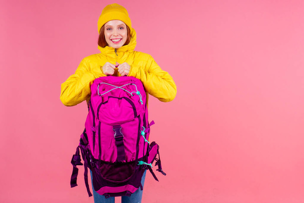 caucasian redhaired ginger woman with backpack and karemat in studio pink background. Ready for mountain adventure - Фото, зображення