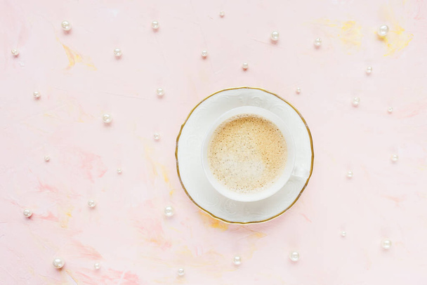 Κύπελλο του μαύρου καφέ σε ροζ με μαργαριτάρια φόντο - Φωτογραφία, εικόνα