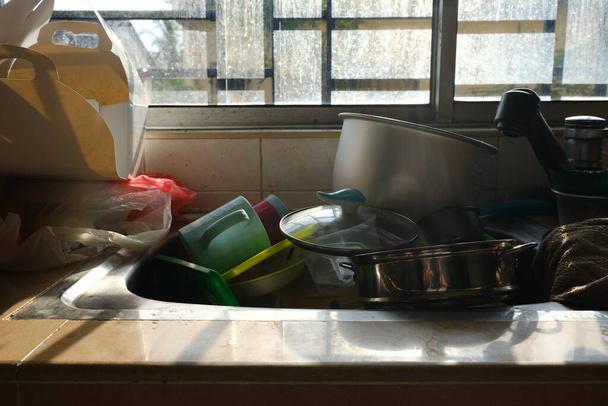 Obrázek umyvadla plného špinavého nádobí v dopoledních hodinách před mytím. - Fotografie, Obrázek