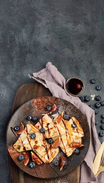 Sweet crepes with figs and chocolate on gray background. Homemade food concept. Top view, flat lay, copy space - Фото, зображення