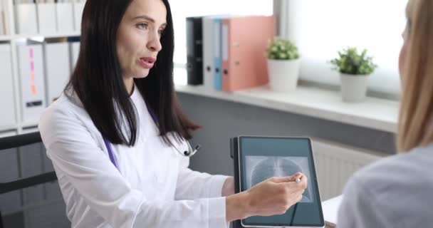 Γυναίκα γιατρός δείχνει ασθενή ακτινογραφία των πνευμόνων σε δισκίο αργή κίνηση 4k ταινία - Πλάνα, βίντεο