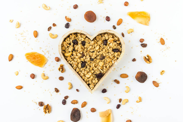 Top view of a heart shaped bow full of crunchy granola. Healthy eating concept. - Photo, Image