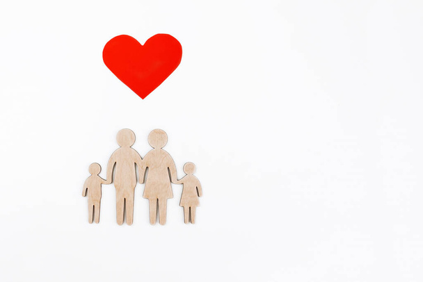 wooden figurine of a family on a white background. Selective focus. Isolated object.Family creation and planning concept. wooden silhouette of a friendly family. - Photo, Image