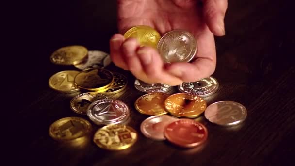 Homme main tenant crypto pièces et Bitcoin d'or sur une table - Séquence, vidéo