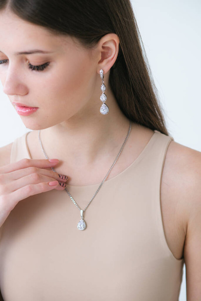 Trending silver jewelry set on a beautiful young girl with long dark hair. Beauty and fashion  - Fotó, kép