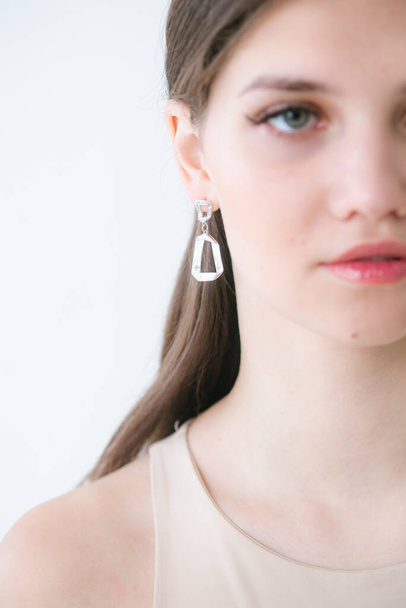 Trendy silver earrings  on a beautiful young girl with long dark hair. Beauty and fashion  - Foto, immagini