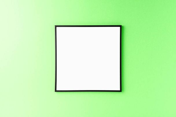 Black picture frame on green background. Mockup with copyspace - Foto, Imagem