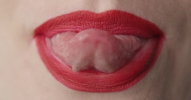 Μια μακρο-φωτογραφία της γυναίκας που δείχνει τη γλώσσα της με κόκκινο κραγιόν στα χείλη της - Πλάνα, βίντεο