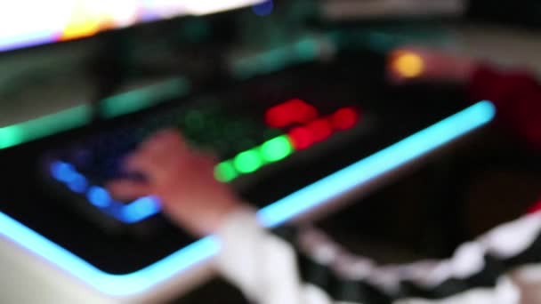 Adolescente jugando juegos de ordenador en la PC de escritorio iluminado como fondo borroso que muestra los esports y la competencia de videojuegos con el equipo eléctrico y el mercado multimedia para los jugadores de actividad de ocio - Metraje, vídeo