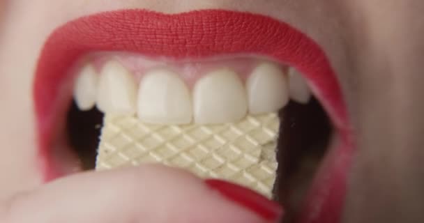 Bijtende wafels met rode lippen een close-up shot van vrouw in slow motion - Video