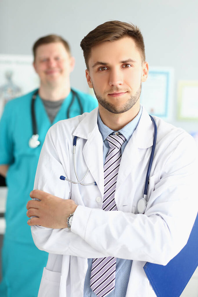 Two male medical workers in uniform at the workplace, - Foto, Imagen