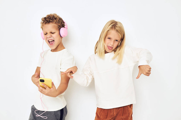 Imagem de menino e menina fones de ouvido com telefone entretenimento luz de fundo - Foto, Imagem