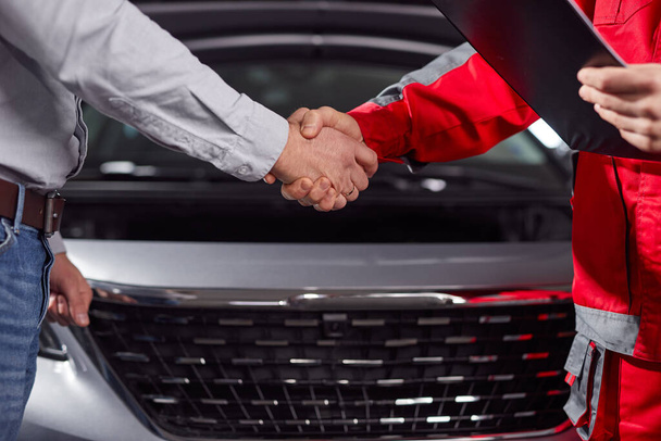 Anonymous mechanic and customer shaking hand after finishing car diagnosis - Photo, Image