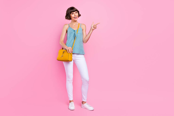 Full length body size view of attractive cheerful girl showing copy space ad isolated over pink pastel color background - Fotó, kép
