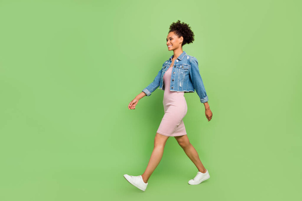Full body profile photo of pretty young lady go wear dress shirt sneakers isolated on green background - Foto, imagen