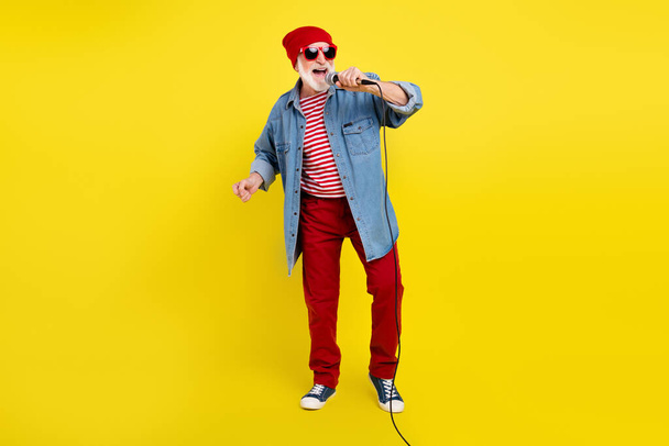 Full length body size view of attractive cheery funky grey-haired man singing hit rock isolated over bright yellow color background - Valokuva, kuva