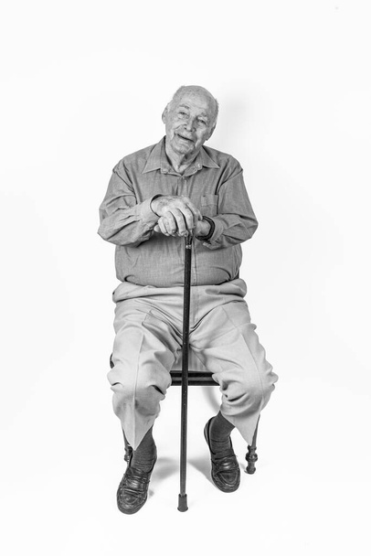 homem idoso feliz sentado na frente de um fundo branco
 - Foto, Imagem