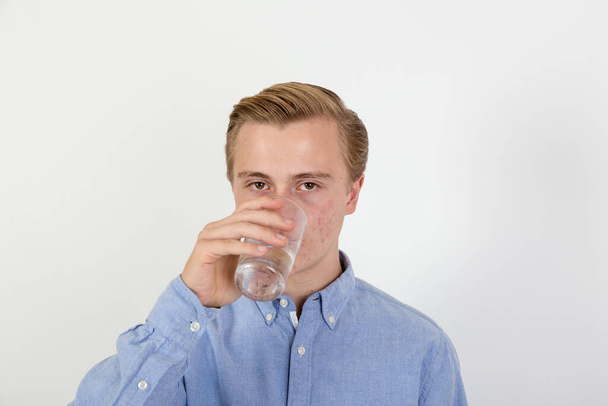 πορτρέτο του έφηβου αγοριού πόσιμο νερό από ένα ποτήρι - Φωτογραφία, εικόνα