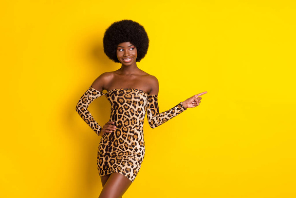Photo of pretty charming dark skin lady wear off-shoulders clothes pointing finger empty space smiling isolated yellow color background - Foto, Imagen